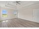 Bright main bedroom with tray ceiling, hardwood floors, and an abundance of natural light at 4022 Macks Rd, Aynor, SC 29511