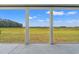 Picturesque view from the covered patio, highlighting the natural beauty of the surrounding landscape and open field at 4022 Macks Rd, Aynor, SC 29511