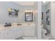Bright bathroom with white cabinets, countertop, decorative shelf, and a framed mirror at 403 Brandymill Blvd, Myrtle Beach, SC 29588