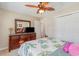 Bedroom featuring wooden dresser, a floral bedspread, ceiling fan, and ensuite access at 403 Brandymill Blvd, Myrtle Beach, SC 29588
