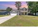 Charming two-story home with a manicured lawn, a palm tree, and a welcoming front porch with rocking chairs at 403 Brandymill Blvd, Myrtle Beach, SC 29588