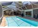 Enclosed in-ground swimming pool with outdoor seating, fireplace, and grill at 403 Brandymill Blvd, Myrtle Beach, SC 29588