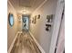 Long hallway with laminate flooring, light gray walls adorned with Gathering pictures, and a view into other rooms at 408 South Farr Ave., Andrews, SC 29510