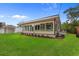 The back of the house is surrounded by a lush lawn and a screened-in porch with several windows at 409 14Th Ave. S, North Myrtle Beach, SC 29582