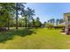 Expansive backyard featuring a lush green lawn with mature trees and landscaping at 414 Staghorn Ln., Longs, SC 29568