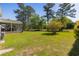 Large backyard featuring lush lawn, mature trees, and a view of the screened-in porch at 414 Staghorn Ln., Longs, SC 29568