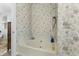 Bathroom with tub and shower, featuring floral wallpaper and neutral finishes at 414 Staghorn Ln., Longs, SC 29568