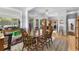 Inviting dining room with hardwood floors, open to kitchen, and abundant natural light from sliding doors at 414 Staghorn Ln., Longs, SC 29568
