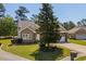 Well-maintained brick home with mature landscaping, a brick-paved walkway, and a two-car garage at 414 Staghorn Ln., Longs, SC 29568