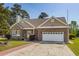 Charming brick home with manicured landscaping, a two-car garage, and a brick-paved walkway at 414 Staghorn Ln., Longs, SC 29568