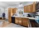 Spacious kitchen featuring wooden cabinets and black appliances plus a large window at 414 Staghorn Ln., Longs, SC 29568