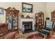 Cozy living room with fireplace, hardwood floors, antique cabinets, and comfortable seating arrangement at 414 Staghorn Ln., Longs, SC 29568