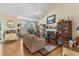 Bright living room showcasing hardwood floors, a fireplace, a large window, and elegant furnishings at 414 Staghorn Ln., Longs, SC 29568