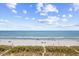 Expansive beach view showcasing white sand and a clear blue ocean under a partly cloudy sky, inviting relaxation at 4311 S Ocean Blvd. # 701, North Myrtle Beach, SC 29582