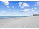 Wide sandy beach with gentle waves, clear skies, and distant buildings, ideal for relaxation and recreation at 4311 S Ocean Blvd. # 701, North Myrtle Beach, SC 29582