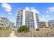 Bright white condo building with private balconies offering stunning views of the beautiful blue sky at 4311 S Ocean Blvd. # 701, North Myrtle Beach, SC 29582
