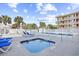 Inviting pool and hot tub area with lounge chairs, tropical landscaping, and a bright blue sky for a resort feel at 4311 S Ocean Blvd. # 701, North Myrtle Beach, SC 29582