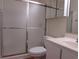Bathroom featuring a shower with sliding glass doors, toilet, vanity, and mirrored cabinet at 5020 Windsor Green Way # 302, Myrtle Beach, SC 29579