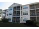 Exterior of a condo with screened-in patios and green lawn at 5020 Windsor Green Way # 302, Myrtle Beach, SC 29579