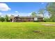 Large backyard with a covered pergola, patio and mature landscaping around the brick home at 5033 Brantwood Dr., Mullins, SC 29574