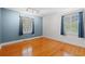 Sunlit bedroom with hardwood floors, blue walls, and two windows with views of the outdoors at 5033 Brantwood Dr., Mullins, SC 29574