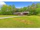 Beautiful brick home with long driveway, lush green lawn, and mature trees at 5033 Brantwood Dr., Mullins, SC 29574