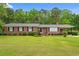 Charming brick home with manicured lawn and landscaping, featuring a cozy covered porch at 5033 Brantwood Dr., Mullins, SC 29574