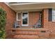 Charming brick front porch with chairs and a 'welcome' sign offering a warm invitation at 5033 Brantwood Dr., Mullins, SC 29574