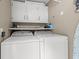 Functional laundry room with washer, dryer, overhead cabinets, and folding shelf at 5033 Brantwood Dr., Mullins, SC 29574