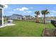Landscaped backyard with palm trees, lush green grass, and pond views at 5039 Gladstone Dr, Conway, SC 29526