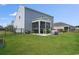 Spacious backyard with well-maintained lawn, screened in porch, and hot tub at 5039 Gladstone Dr, Conway, SC 29526