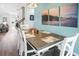 Dining area with wood table, white chairs, wood-style flooring, and seaside-themed wall art at 5039 Gladstone Dr, Conway, SC 29526
