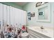This bathroom features a toilet, a vanity with a sink, a shower with a curtain, a mirror, and framed artwork at 504 A S 19Th Ave. S, North Myrtle Beach, SC 29582