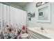 This bathroom features a toilet, a vanity with a sink, a shower with a curtain, a mirror, and framed artwork at 504 A S 19Th Ave. S, North Myrtle Beach, SC 29582