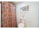 This bathroom features a toilet, a shower with a patterned curtain, framed artwork, and a towel rack at 504 A S 19Th Ave. S, North Myrtle Beach, SC 29582