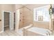 Beautiful bathroom featuring a tub, shower, and a decorative window, offering a spa-like experience at 5647 S Blackmoor Dr., Murrells Inlet, SC 29576