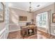 Elegant home office with rich wooden desk, built-in bookshelves, and ample natural light at 5647 S Blackmoor Dr., Murrells Inlet, SC 29576