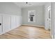 A minimalist bedroom with wainscoting, light-colored walls, and wood-look flooring at 6001 S Kings Hwy., Myrtle Beach, SC 29575
