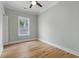 Empty bedroom featuring light green walls, hardwood floors, white trim, and a large window at 6001 S Kings Hwy., Myrtle Beach, SC 29575