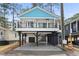 Charming raised beach house with a blue roof and black iron railings on the elevated porch at 6001 S Kings Hwy., Myrtle Beach, SC 29575