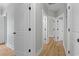 Hallway with light gray walls and hardwood floors, with doors leading to various rooms at 6001 S Kings Hwy., Myrtle Beach, SC 29575