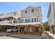 Coastal home featuring elevated design with covered parking and outdoor balcony with comfortable outdoor seating at 6001-1205 S Kings Hwy., Myrtle Beach, SC 29575
