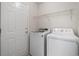 Functional laundry area with modern washer and dryer, overhead shelving, and convenient access door at 622 Oakhurst Dr., Myrtle Beach, SC 29579