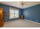 Empty bedroom featuring blue walls, carpet flooring, window and ceiling fan at 6486 Somersby Dr., Murrells Inlet, SC 29576