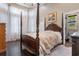 Elegant bedroom featuring a four-poster bed, hardwood floors, and bright natural light from large windows at 8008 Mcsweeney Ct., Myrtle Beach, SC 29588