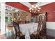 Elegant dining room showcasing a stone archway, dark wood furniture, and ornate chandelier at 8008 Mcsweeney Ct., Myrtle Beach, SC 29588