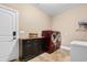 Functional laundry room equipped with modern red washer and dryer, storage cabinet, and sink at 8008 Mcsweeney Ct., Myrtle Beach, SC 29588