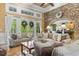 Well-lit living room with stone accent wall, coffered ceiling, and an open doorway to a spacious kitchen at 8008 Mcsweeney Ct., Myrtle Beach, SC 29588