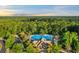 Aerial view of community pool with chairs, umbrellas, bathrooms, and adjacent clubhouse at 8008 Mcsweeney Ct., Myrtle Beach, SC 29588