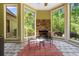 Bright sunroom featuring a stone fireplace, large windows with a view, and a stone tile floor at 8008 Mcsweeney Ct., Myrtle Beach, SC 29588